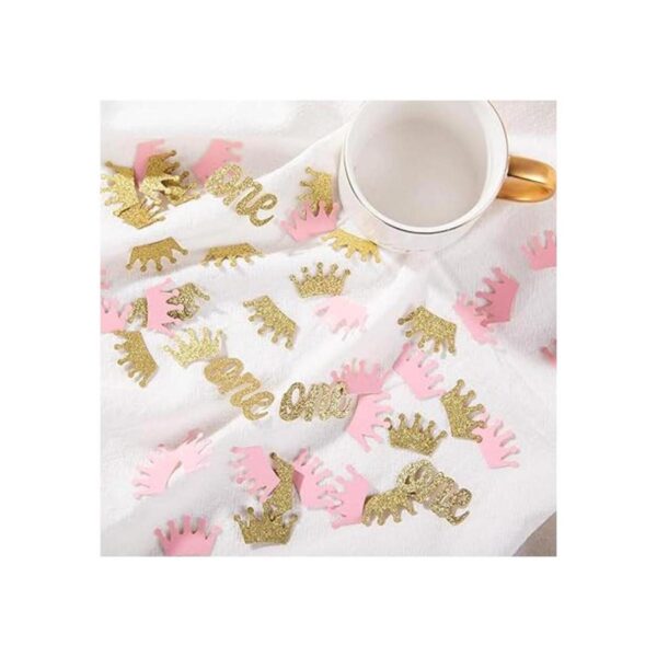 Confeti de corona con purpurina rosa y dorado una mesa de