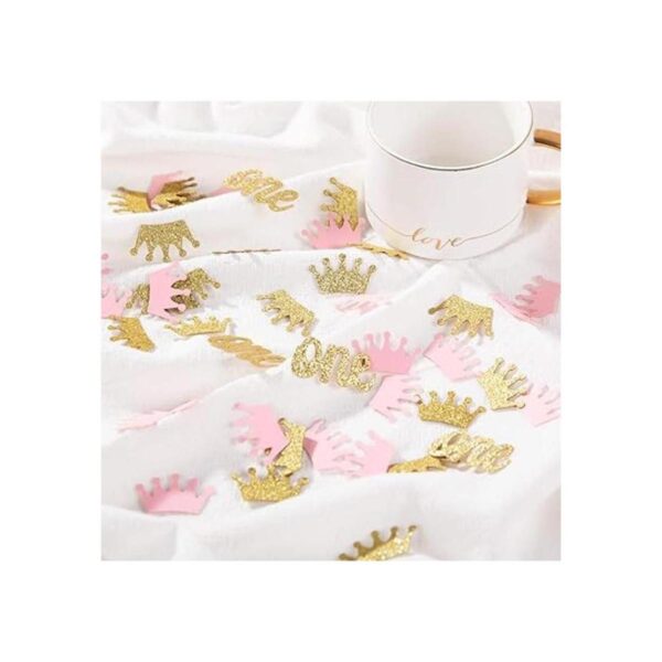 Confeti de corona con purpurina rosa y dorado una mesa de